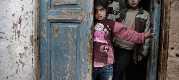 Crianças sírias abrigadas na entrada de uma casa, em meio a tiros e bombardeios, em uma cidade afetada pelo conflito. Foto: UNICEF/ Alessio Romenzi