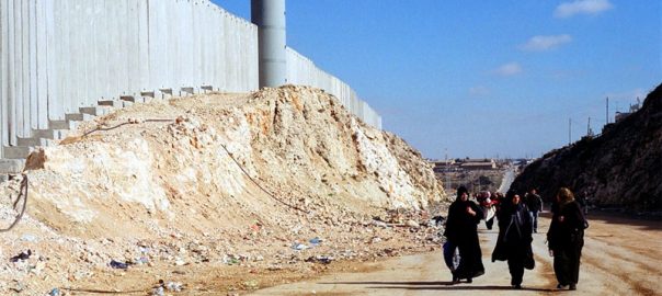 Mulheres palestinas caminham próximo ao muro construído por Israel na região, perto de Ramallah, na Cisjordânia. Foto: IRIN/Shabtai Gold